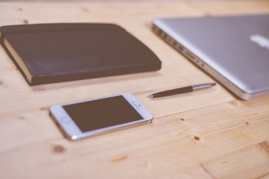 iPhone and MacBook on Wooden Desk