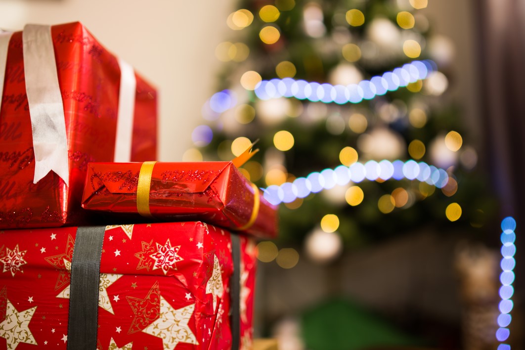 bottom view small gifts tied with red ribbon santa hat on dark red table  free space Stock Photo by ImgSolut