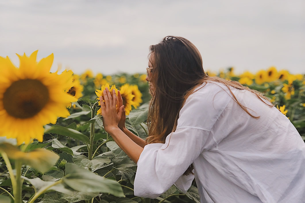 Woman Smelling Sunflowers