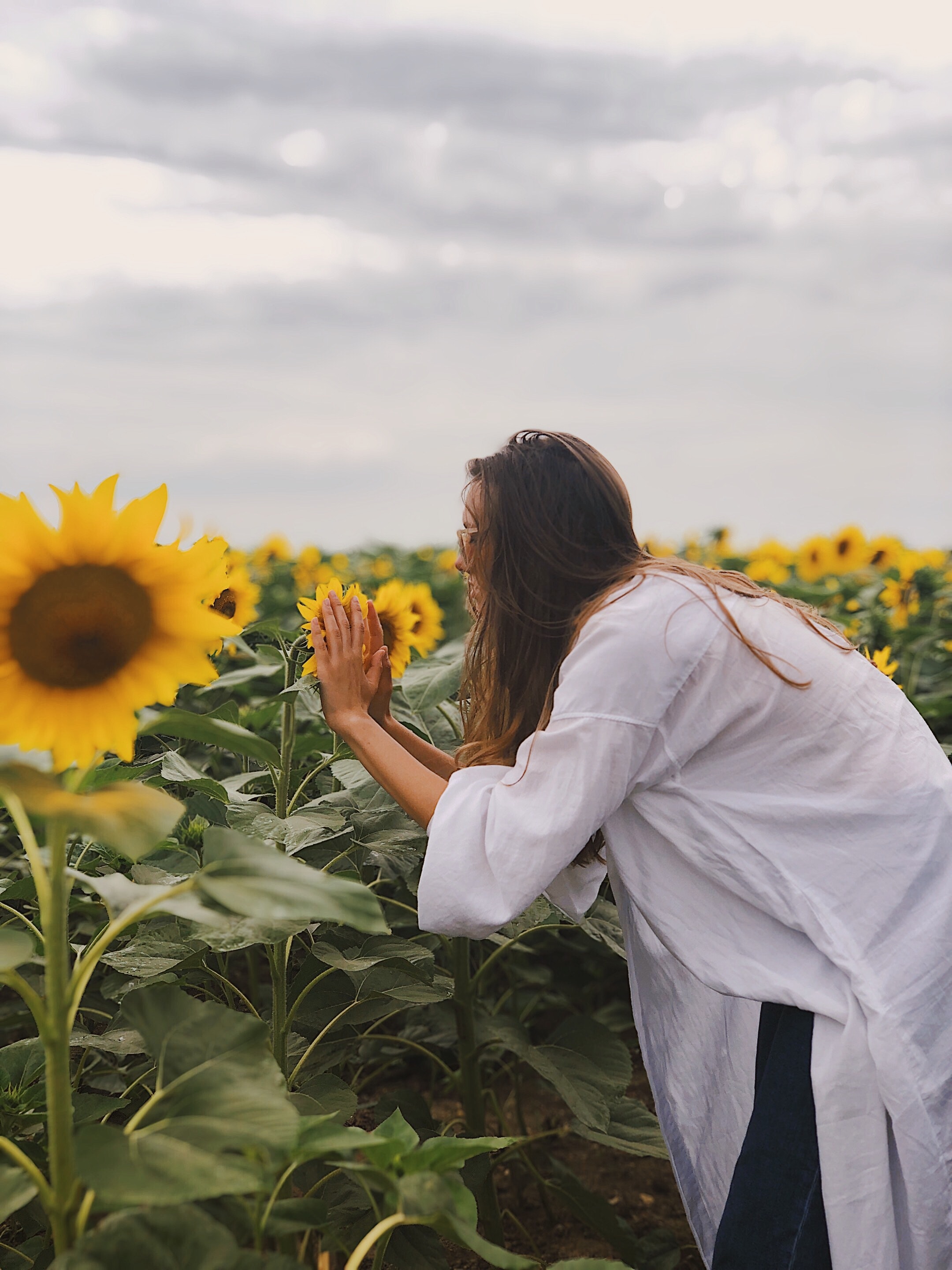 Woman Smelling Sunflowers