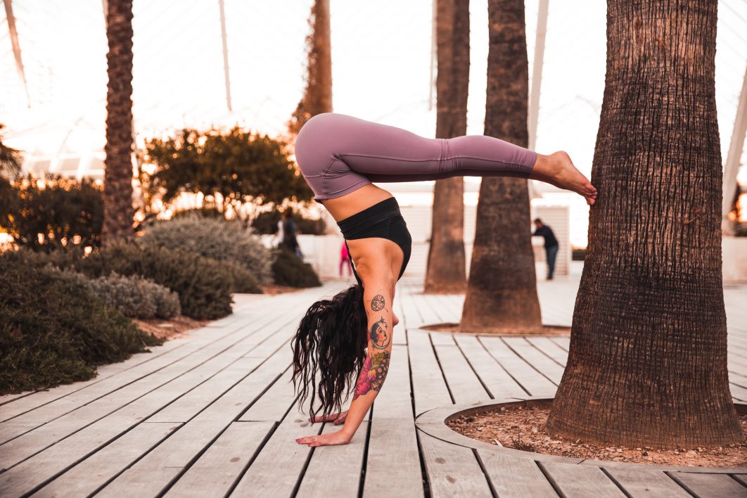 A Woman in Beige Long Sleeve Dress Doing Yoga Poses Near a Tree Trunk ·  Free Stock Photo