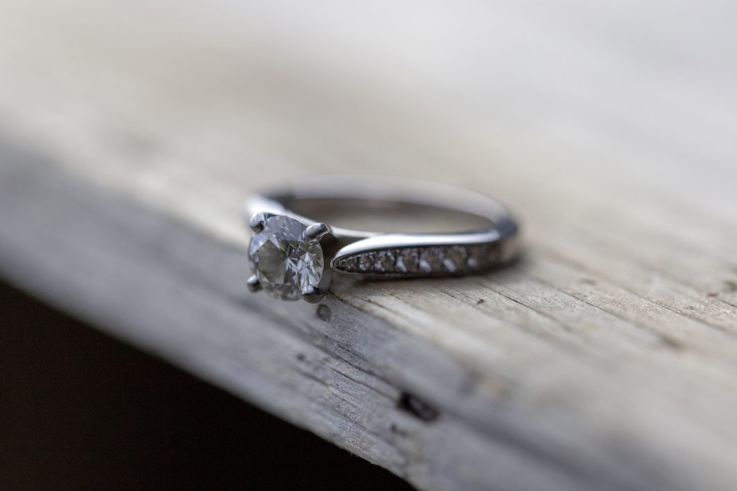 Diamond jewelery ring for social media display. Wedding ring photographed  on white stone. Engagement ring with gemstones. Wedding rings isolated on a  bright white background, focus blur. Gold ring. 8032316 Stock Photo