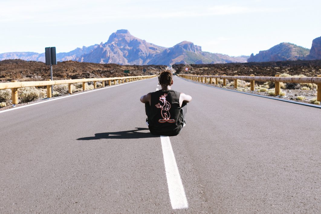 Man sitting in empty road